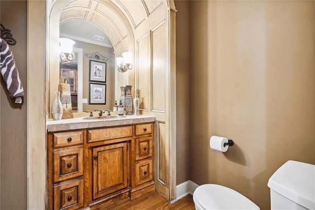 10233 N Prospect Ave, Kansas City, MO 64155 - bathroom featuring toilet, ornamental molding, vanity, wood finished floors, and baseboards