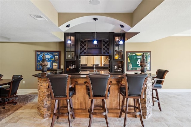 10233 N Prospect Ave, Kansas City, MO 64155 - indoor wet bar with baseboards, decorative light fixtures, and light stone finish floors