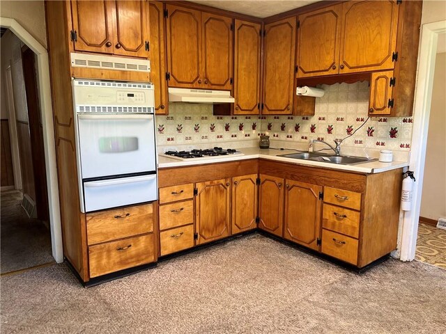 5720 NW 51st St, Kansas City, MO 64151 - kitchen featuring white appliances, a warming drawer, a sink, under cabinet range hood, and brown cabinets