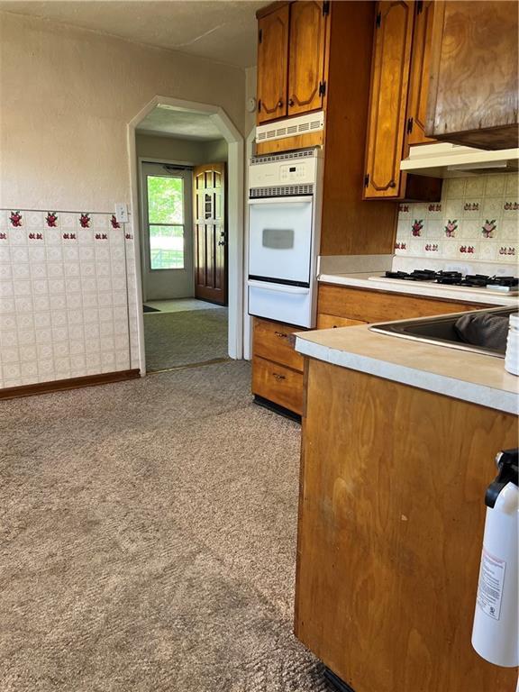 5720 NW 51st St, Kansas City, MO 64151 - kitchen featuring white appliances, a warming drawer, brown cabinets, and light countertops