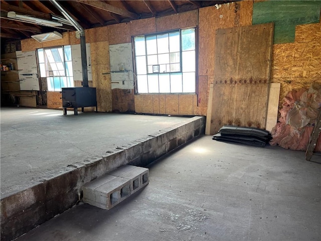 5720 NW 51st St, Kansas City, MO 64151 - miscellaneous room featuring a wood stove, healthy amount of natural light, and unfinished concrete floors