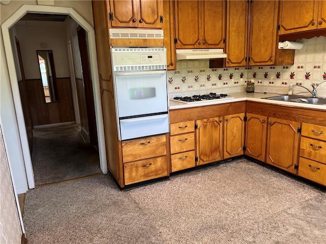 5720 NW 51st St, Kansas City, MO 64151 - kitchen featuring a warming drawer, white appliances, under cabinet range hood, light countertops, and a sink