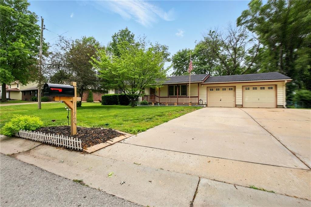 1172 S Delaware Dr, Tonganoxie, KS 66086 - single story home featuring a porch, an attached garage, a front yard, and concrete driveway