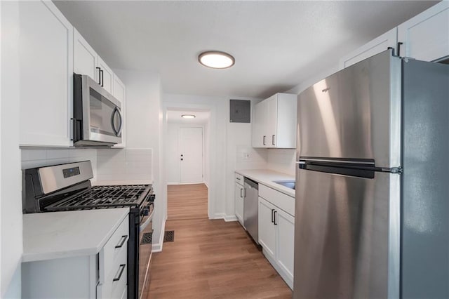228 N 26th St, Kansas City, KS 66102 - kitchen featuring stainless steel appliances, backsplash, and white cabinetry
