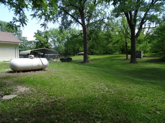 6780 SW County Road 2007th Rd, Rich Hill, MO 64779 - view of green lawn featuring a carport