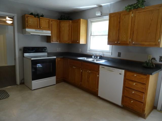 6780 SW County Road 2007th Rd, Rich Hill, MO 64779 - kitchen featuring range with electric cooktop, white dishwasher, under cabinet range hood, a sink, and brown cabinetry