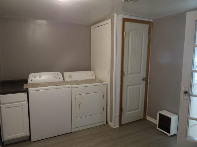 6780 SW County Road 2007th Rd, Rich Hill, MO 64779 - laundry room featuring washer and clothes dryer, cabinet space, wood finished floors, and baseboards