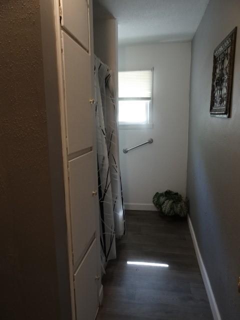 6780 SW County Road 2007th Rd, Rich Hill, MO 64779 - laundry area featuring wood finished floors and baseboards