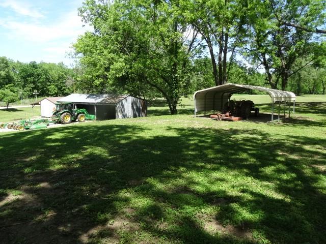 6780 SW County Road 2007th Rd, Rich Hill, MO 64779 - view of green lawn featuring a detached carport and an outdoor structure