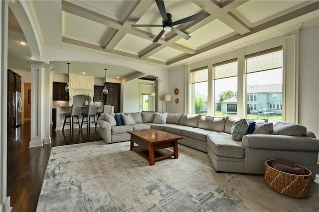 15601 Windsor St, Overland Park, KS 66224 - living area with arched walkways, ceiling fan, decorative columns, dark wood-type flooring, and coffered ceiling
