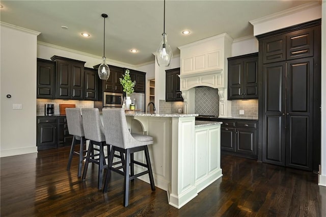 15601 Windsor St, Overland Park, KS 66224 - kitchen with stainless steel appliances, tasteful backsplash, dark wood finished floors, a center island with sink, and recessed lighting