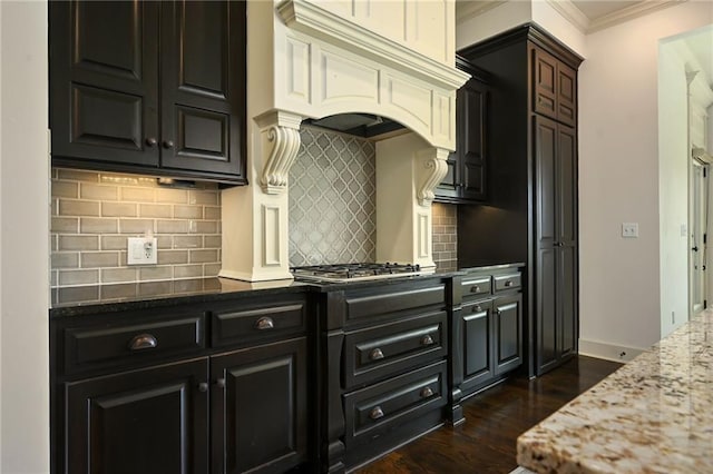 15601 Windsor St, Overland Park, KS 66224 - kitchen with dark wood-style floors, ornamental molding, backsplash, stainless steel gas stovetop, and light stone countertops
