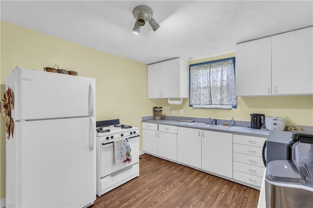 kitchen featuring white appliances, a sink, dark wood-type flooring, and white cabinetry