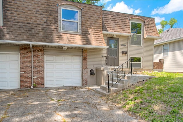 9406 Switzer St, Overland Park, KS 66214 - view of front of house featuring mansard roof, a shingled roof, and driveway
