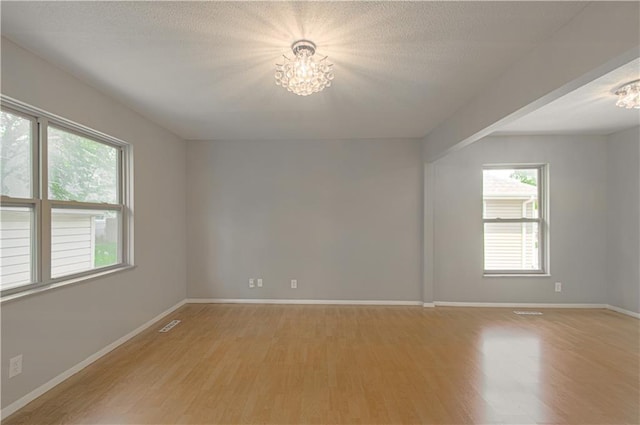 9406 Switzer St, Overland Park, KS 66214 - spare room with a chandelier, light wood-style flooring, plenty of natural light, and baseboards