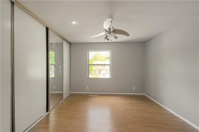 9406 Switzer St, Overland Park, KS 66214 - unfurnished room with light wood-style flooring, a ceiling fan, a textured ceiling, and baseboards