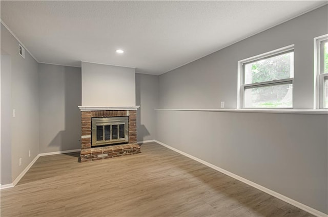 9406 Switzer St, Overland Park, KS 66214 - unfurnished living room featuring a fireplace, wood finished floors, baseboards, and recessed lighting
