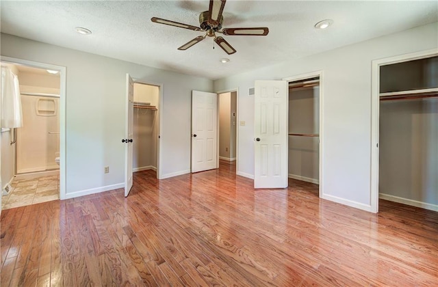 1014 SW Twilight Ln, Blue Springs, MO 64015 - unfurnished bedroom with two closets, wood finished floors, connected bathroom, ceiling fan, and recessed lighting