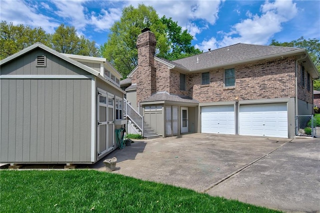 1014 SW Twilight Ln, Blue Springs, MO 64015 - back of house with stairway, driveway, a chimney, an attached garage, and brick siding