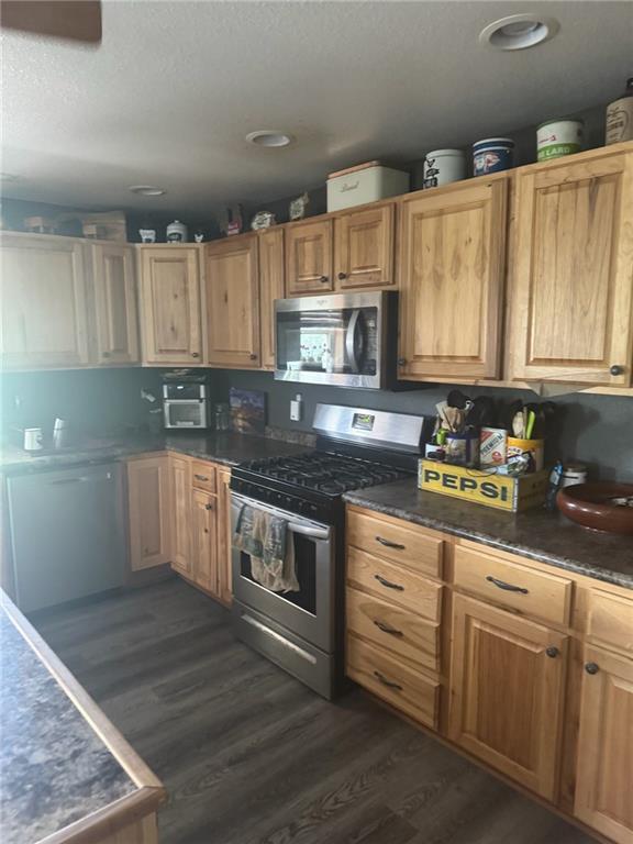 8000 County Road 43, Rosendale, MO 64483 - kitchen with appliances with stainless steel finishes, dark wood-style flooring, a textured ceiling, dark countertops, and recessed lighting