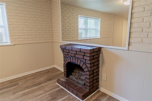 10203 Fremont Ave, Kansas City, MO 64134 - detailed view of wood finished floors, a wainscoted wall, and brick wall