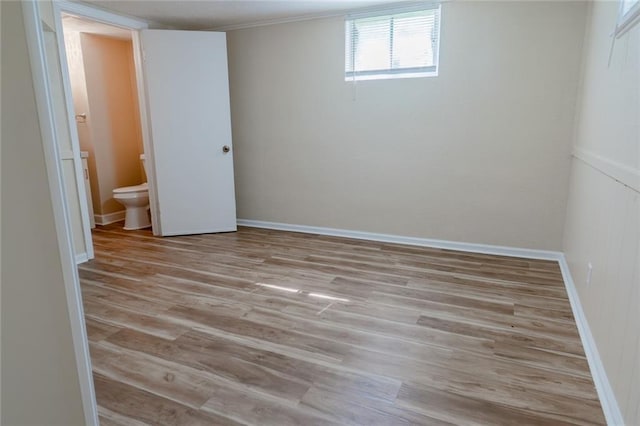 10203 Fremont Ave, Kansas City, MO 64134 - unfurnished bedroom featuring wood finished floors, baseboards, and ensuite bathroom