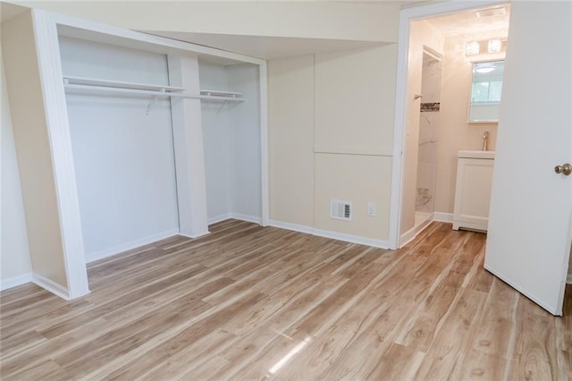 10203 Fremont Ave, Kansas City, MO 64134 - unfurnished bedroom with light wood finished floors, a closet, baseboards, and ensuite bath