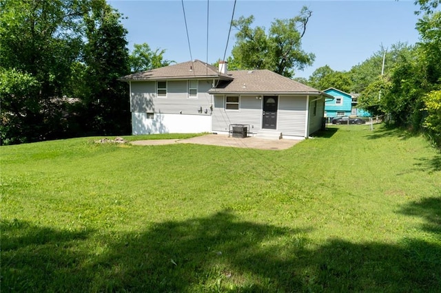 10203 Fremont Ave, Kansas City, MO 64134 - rear view of property featuring a patio area, a lawn, and central AC unit