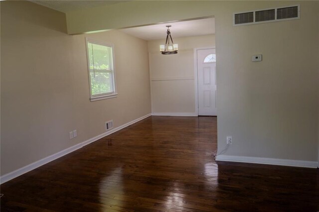 10203 Fremont Ave, Kansas City, MO 64134 - unfurnished room with wood-type flooring, baseboards, and a chandelier