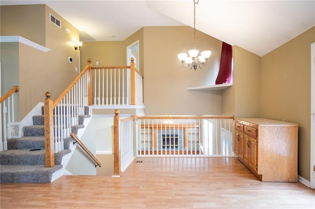 1703 Rolling Rock Rd, Raymore, MO 64083 - stairway with wood finished floors, a chandelier, and high vaulted ceiling