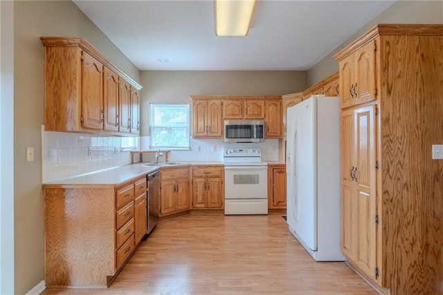 1703 Rolling Rock Rd, Raymore, MO 64083 - kitchen with appliances with stainless steel finishes, light wood-style flooring, backsplash, and light countertops