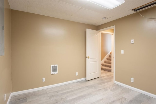 1703 Rolling Rock Rd, Raymore, MO 64083 - spare room featuring light wood finished floors, stairway, heating unit, and a paneled ceiling