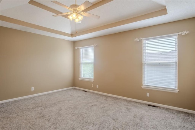 1703 Rolling Rock Rd, Raymore, MO 64083 - spare room with a raised ceiling, carpet flooring, and a ceiling fan