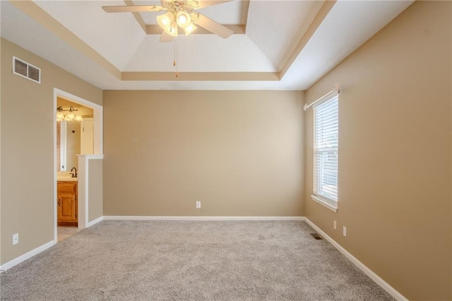 1703 Rolling Rock Rd, Raymore, MO 64083 - spare room with a tray ceiling, light colored carpet, and a ceiling fan
