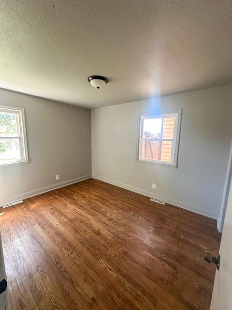 307 SW Glendana St, Lees Summit, MO 64081 - unfurnished room with dark wood-style flooring, a textured ceiling, and baseboards