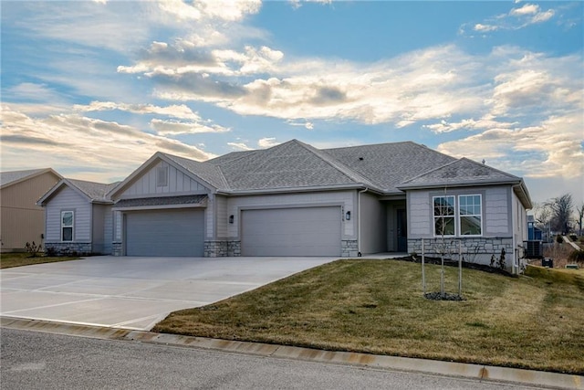 single story home with stone siding, an attached garage, a front lawn, concrete driveway, and board and batten siding