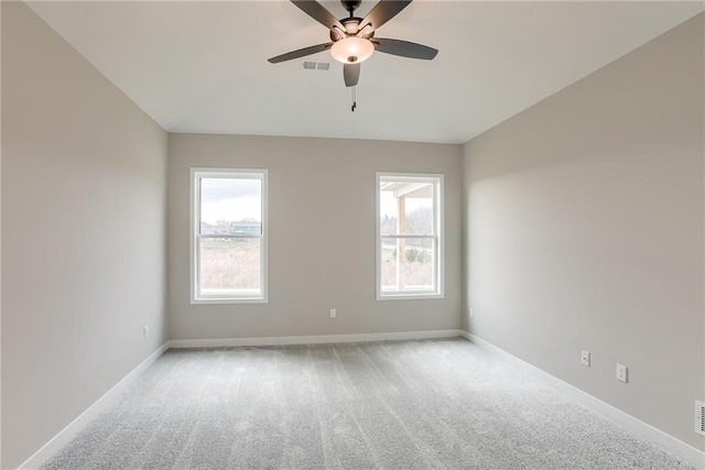 unfurnished room featuring light colored carpet, ceiling fan, vaulted ceiling, and baseboards