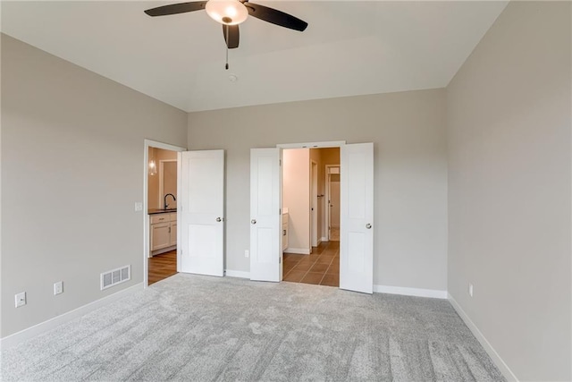 unfurnished bedroom with carpet, baseboards, and ensuite bath