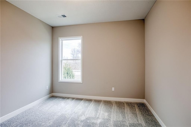 carpeted empty room featuring baseboards