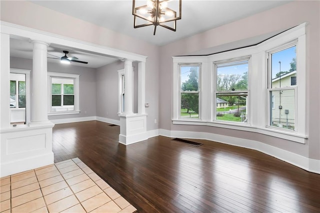 312 2nd St, Ferrelview, MO 64163 - unfurnished living room featuring decorative columns, dark wood-type flooring, baseboards, and ceiling fan