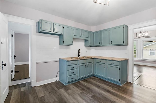 312 2nd St, Ferrelview, MO 64163 - kitchen featuring dark wood finished floors, a chandelier, a sink, blue cabinetry, and decorative backsplash