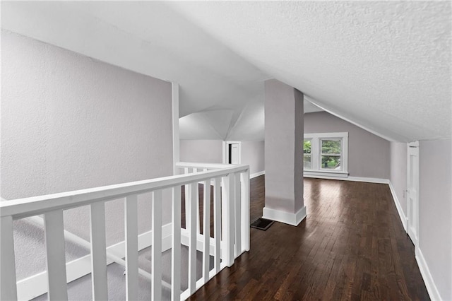 312 2nd St, Ferrelview, MO 64163 - hallway featuring wood-type flooring, a textured ceiling, baseboards, lofted ceiling, and a textured wall