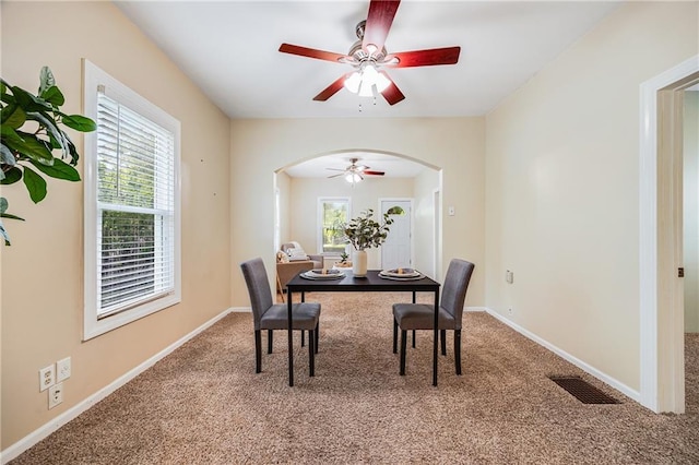 1503 S Spring St, Independence, MO 64055 - dining room with arched walkways, a ceiling fan, carpet flooring, and baseboards