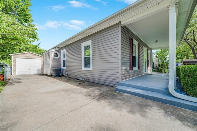 1503 S Spring St, Independence, MO 64055 - view of home's exterior featuring an outdoor structure, a porch, a detached garage, and concrete driveway