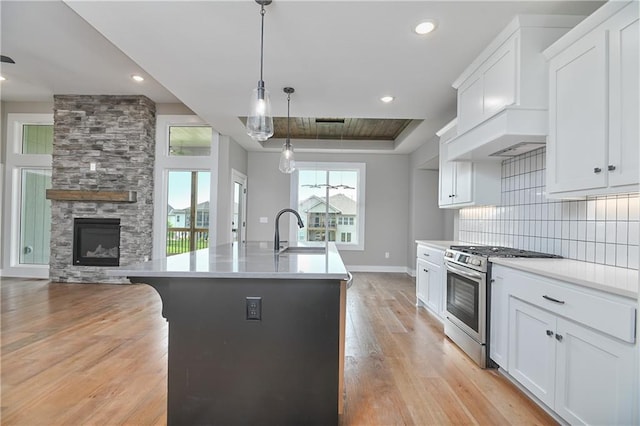 24105 W 58th Pl, Shawnee, KS 66226 - kitchen with stainless steel gas range, a sink, baseboards, light wood-style floors, and tasteful backsplash