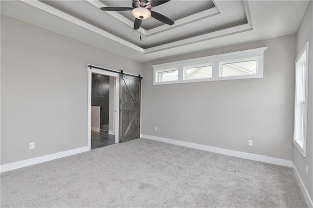 24105 W 58th Pl, Shawnee, KS 66226 - unfurnished bedroom featuring carpet floors, a tray ceiling, a barn door, and baseboards