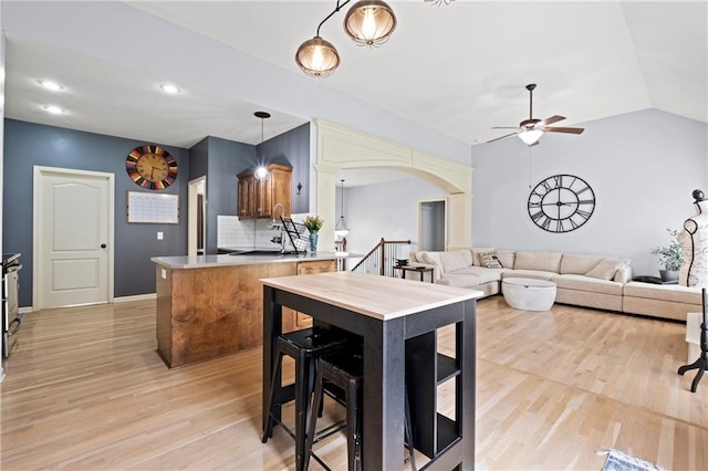 1523 Honeysuckle Dr, Liberty, MO 64068 - kitchen with a ceiling fan, a peninsula, light wood-type flooring, arched walkways, and lofted ceiling