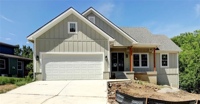 220 Rock Bridge Pkwy, Excelsior Springs, MO 64024 - view of front of home with board and batten siding, concrete driveway, an attached garage, and roof with shingles