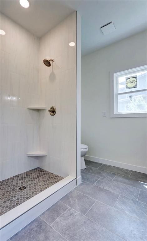 220 Rock Bridge Pkwy, Excelsior Springs, MO 64024 - bathroom featuring a tile shower, toilet, and baseboards