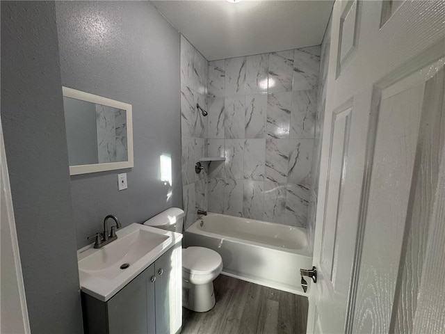 bathroom featuring wood finished floors, shower / tub combination, vanity, and toilet